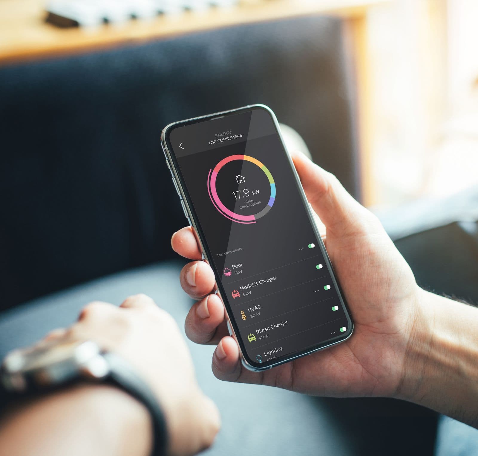 A hand holding a phone with the Savant energy dashboard