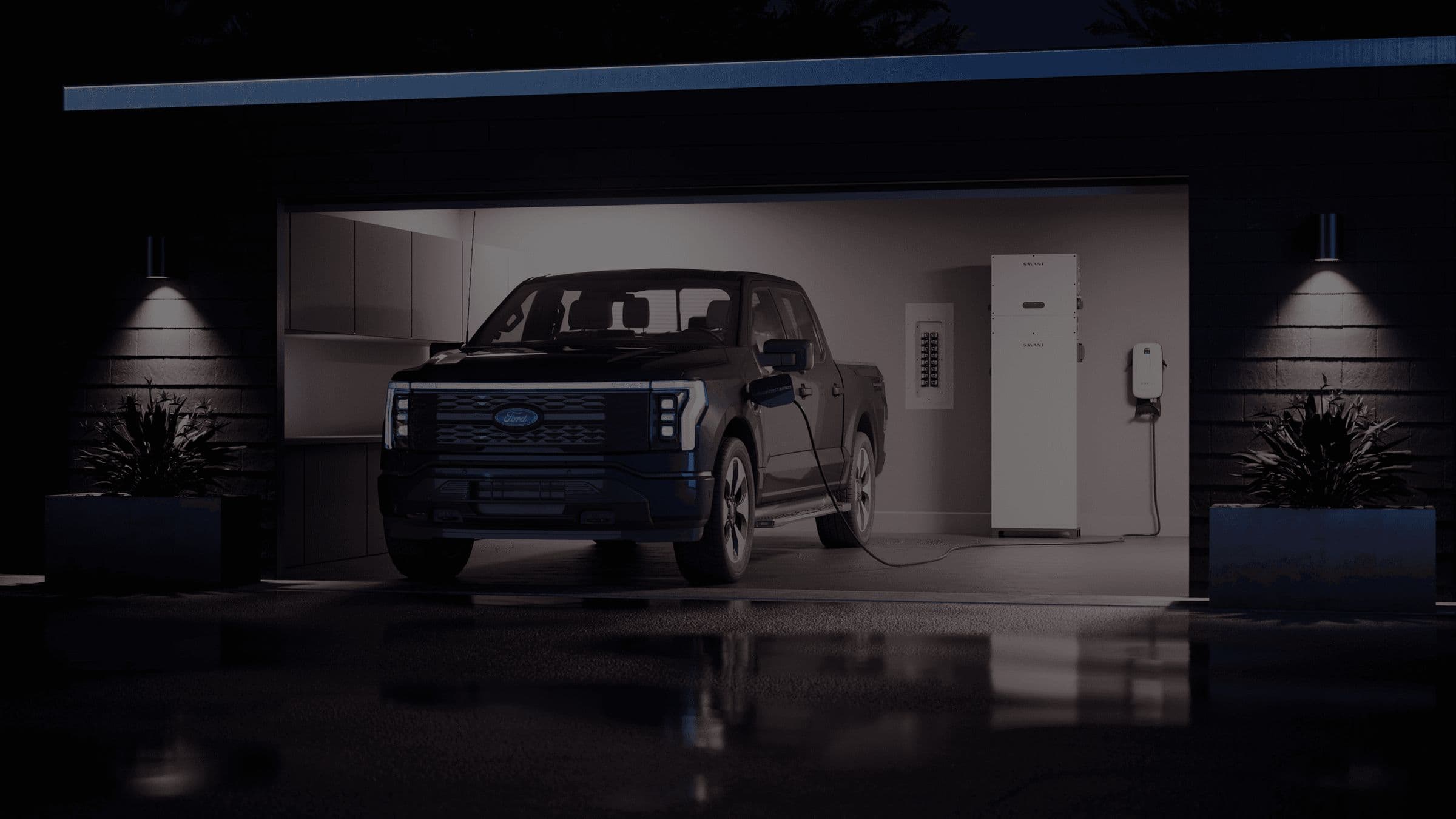 A garage at night with a Savant Power Storage 20 and a charging truck